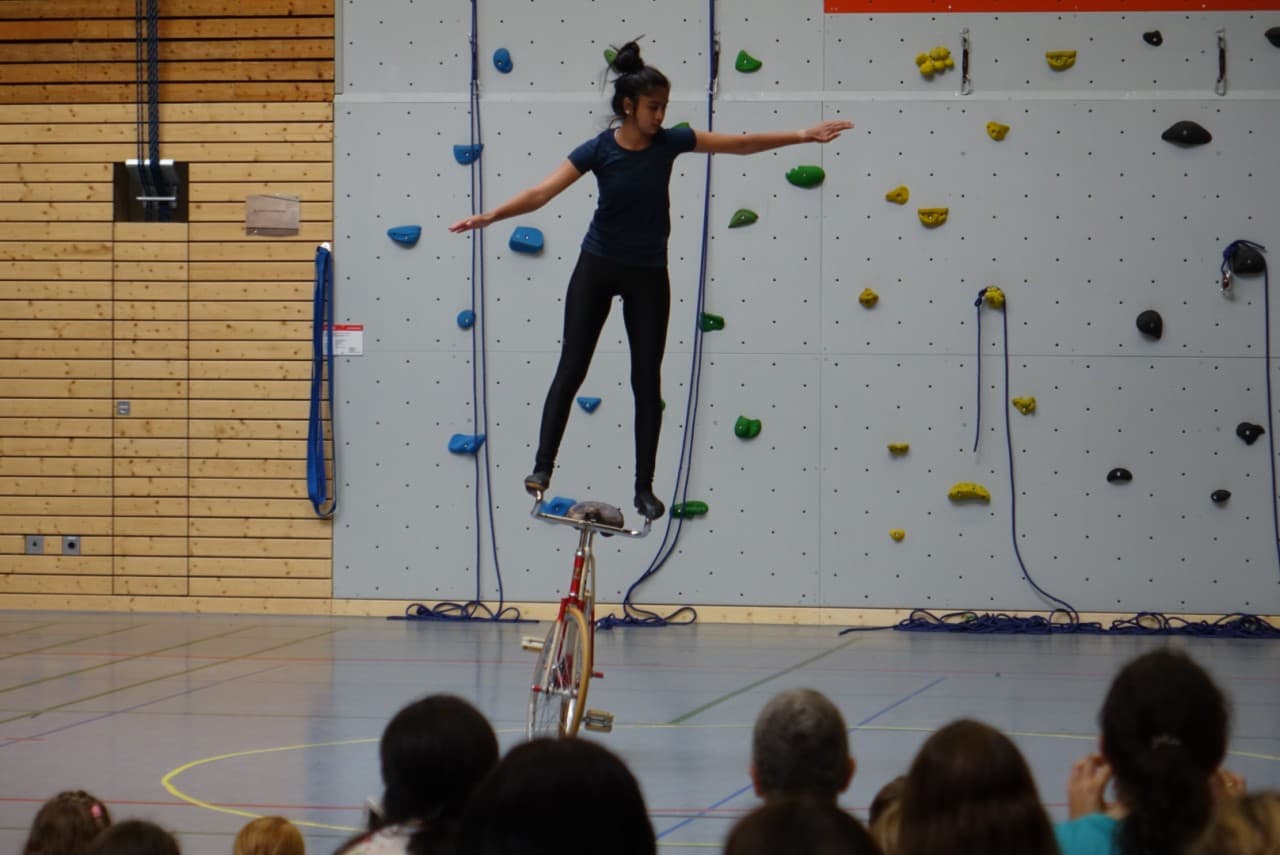 Artistin balanciert bei der Sportgala auf einem Hochrad